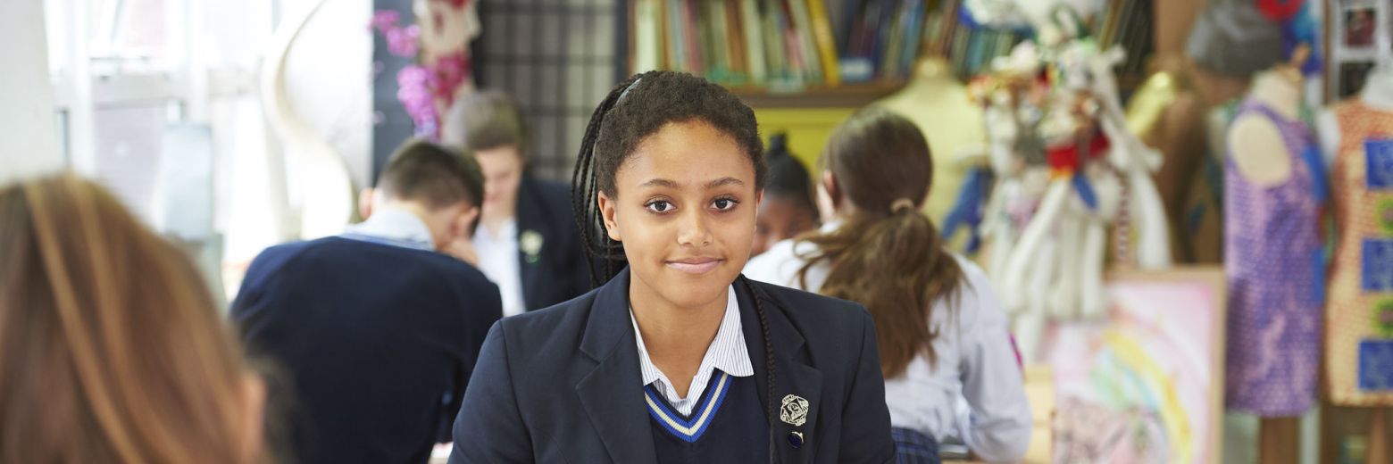 teenage girl sitting at a desk in class