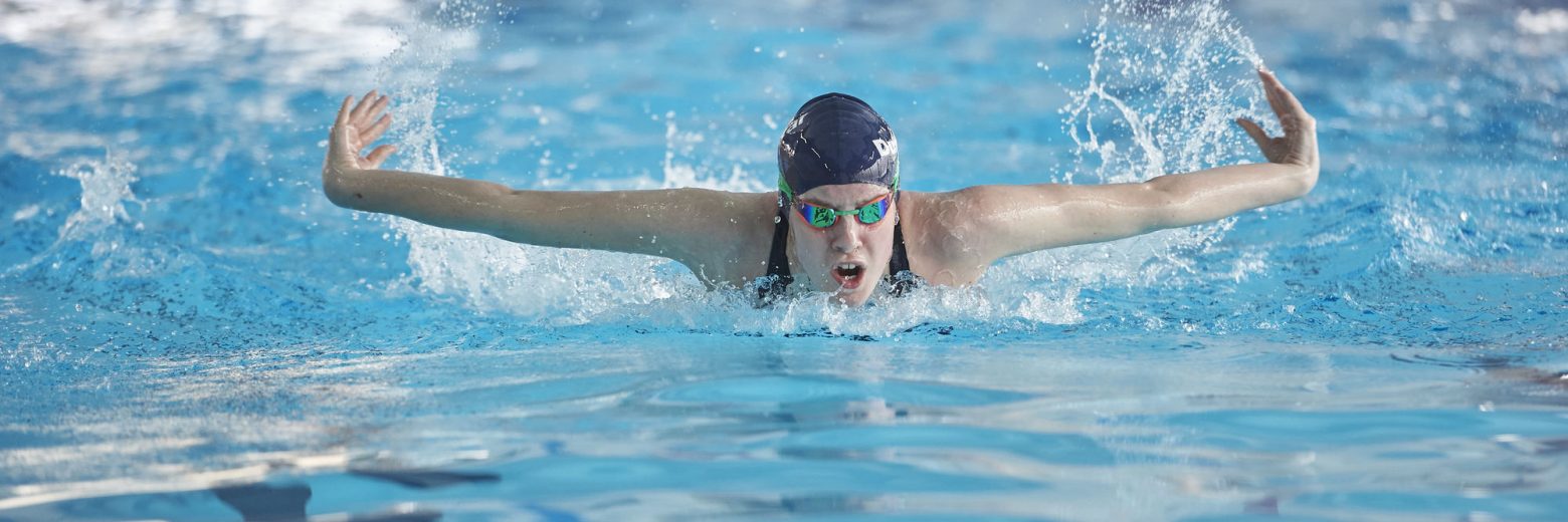 Student swimming with arms out