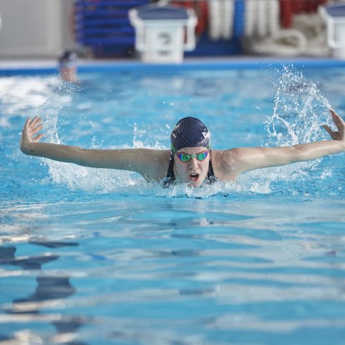 Student swimming with arms out