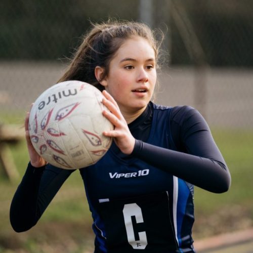 school girl holding a netball