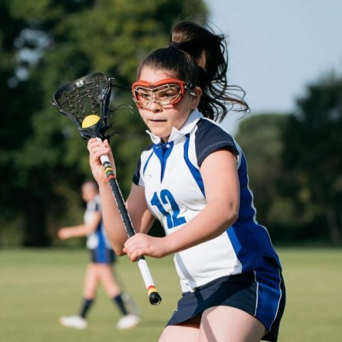 school girl holding a lacrosse stick