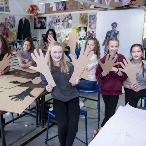 students with carboard cut outs of hands