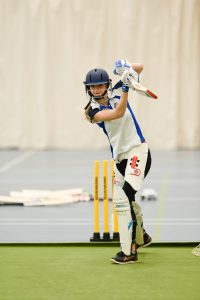 Girl hitting ball with her bat