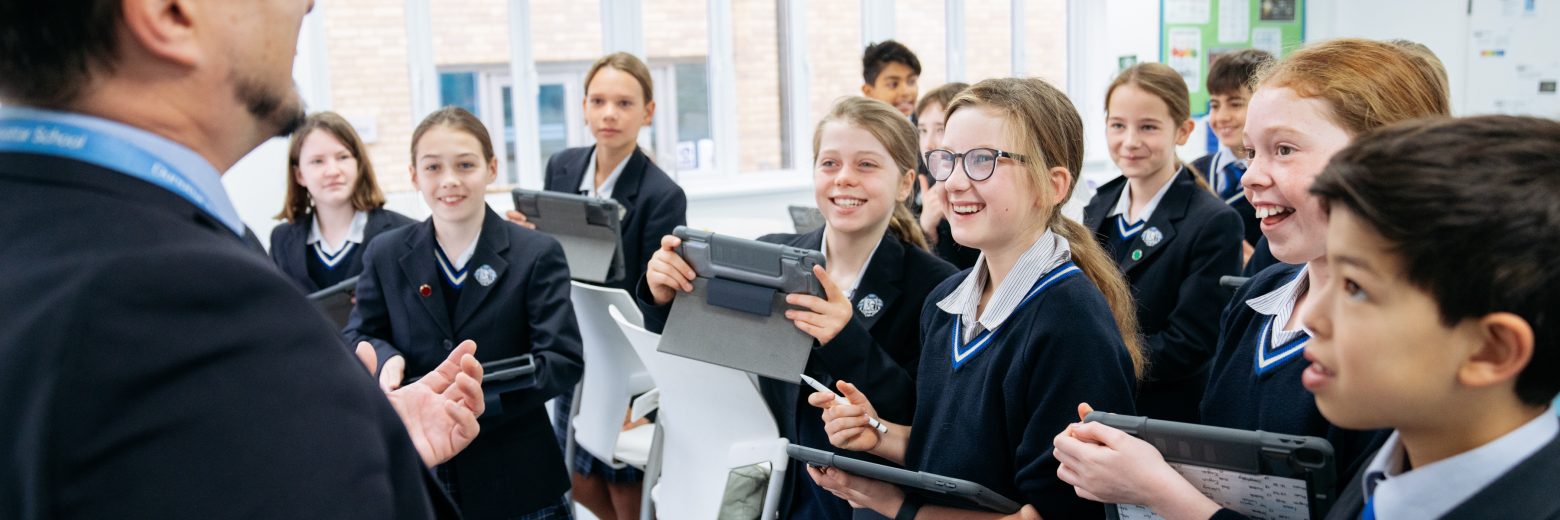 students holding tablets and smiling