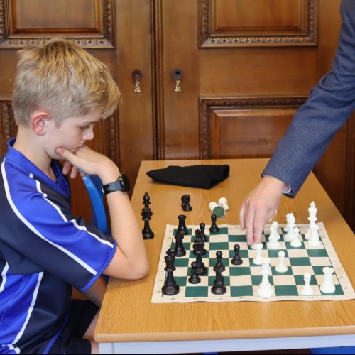boy playing chess with his teacher