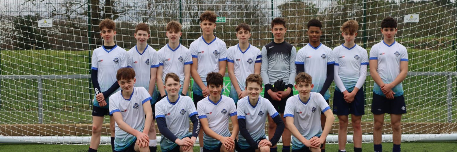 Boys posing for a photo in front of a goal post