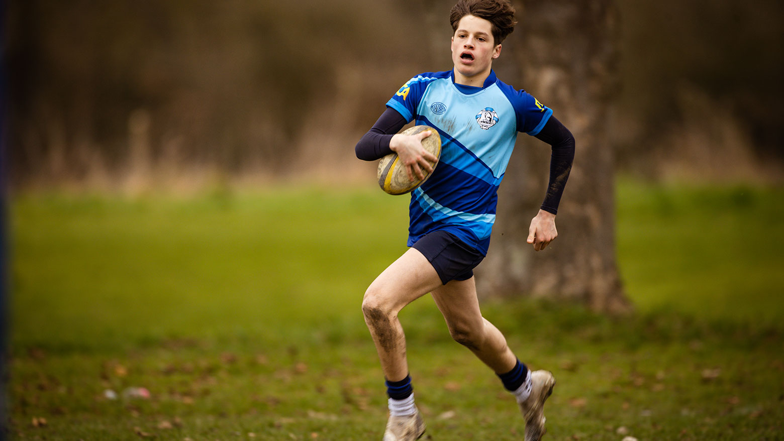 Student running with rugby ball