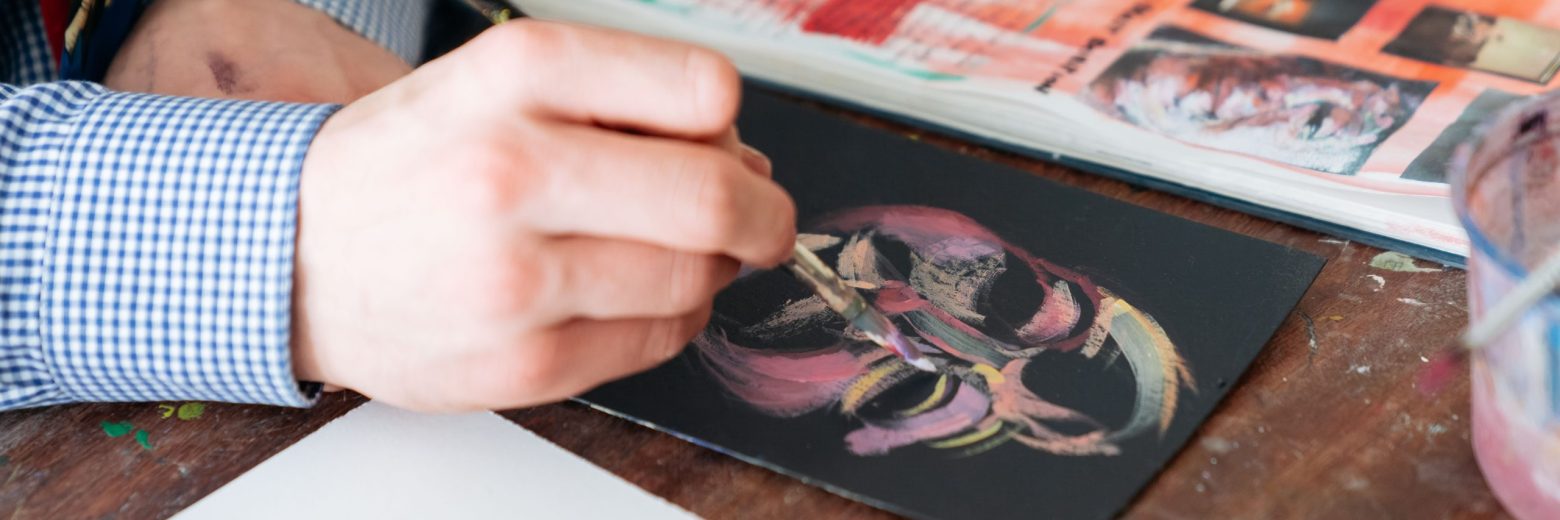 Student painting onto a black canvas