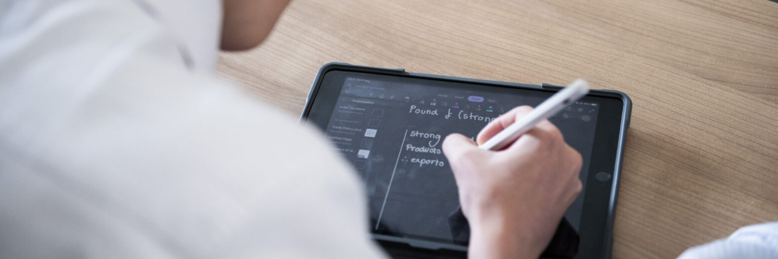 student writing on an ipad