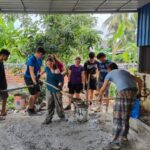 students shovelling mud
